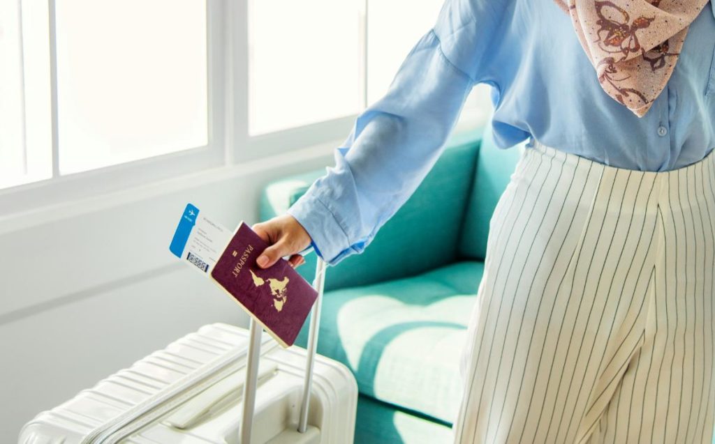 woman with passport and white suitcase