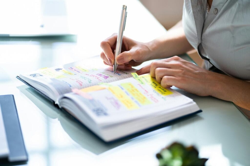 woman writing in a physical planner