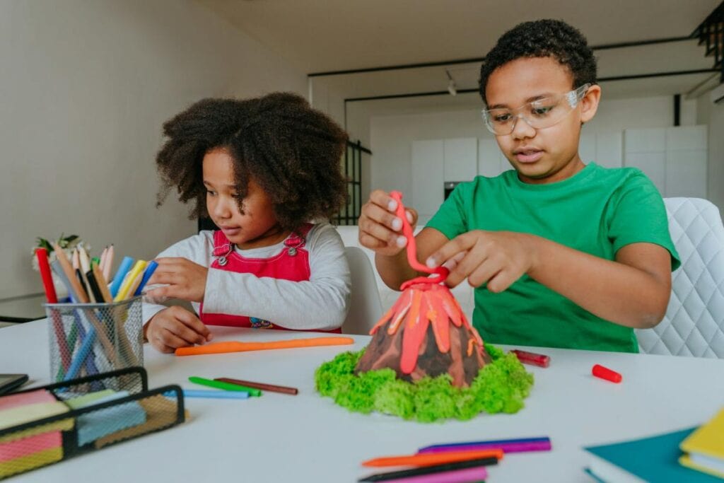 boy and girl working on a model volcano together
