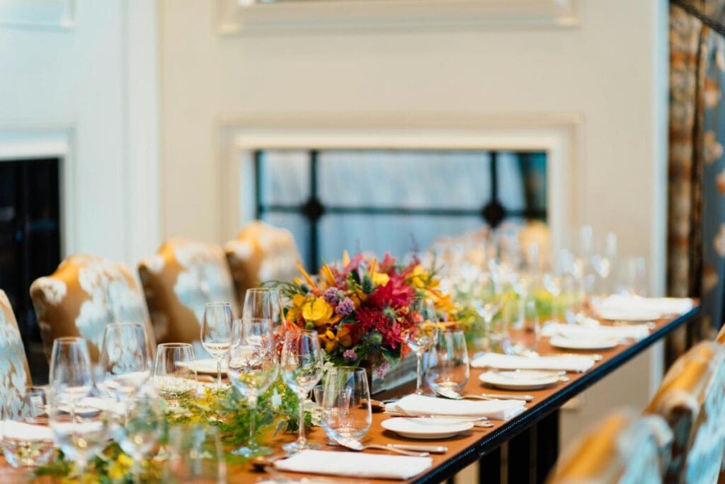 a gorgeous table with flowers, wine glasses, and elegant dinnerware, perfect for hosting dinner for friends
