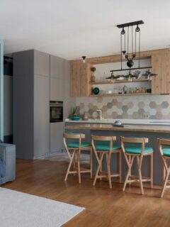 Stylish modern kitchen with hexagon tile backsplash, open shelving, pendant lights, and wood-accented cabinets—ideal for a weekend makeover project.