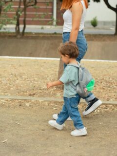 mom walking toddler boy to school