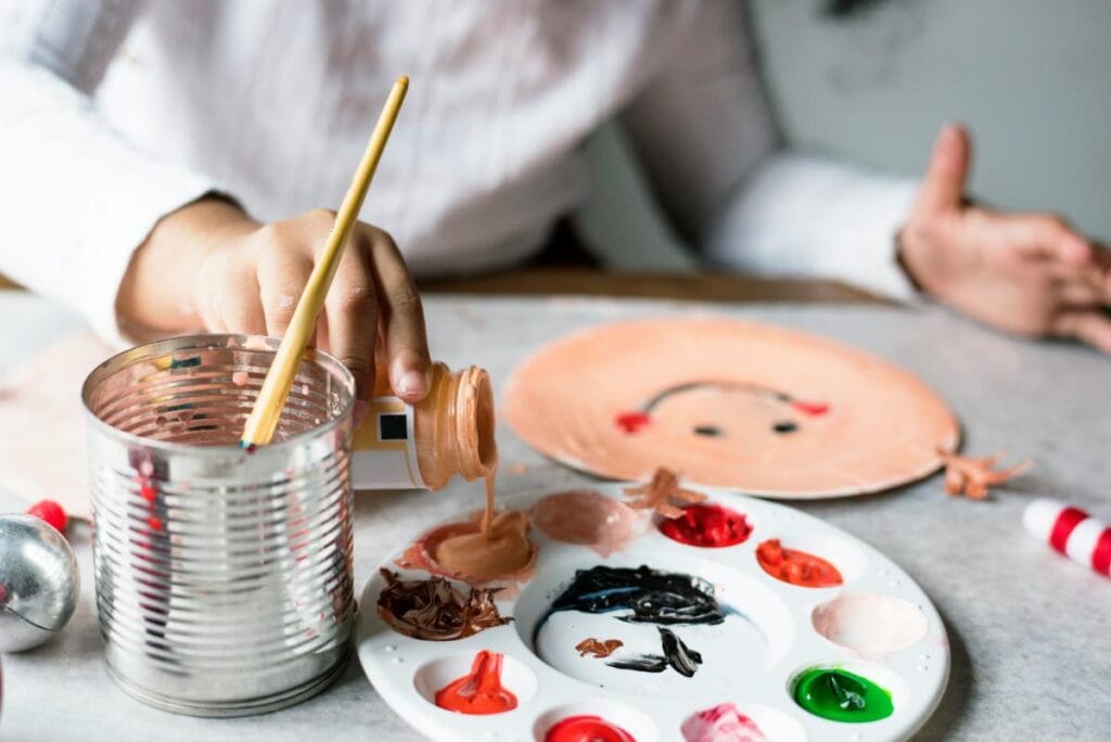 child painting a paper plate to make a paper plate gingerbread man