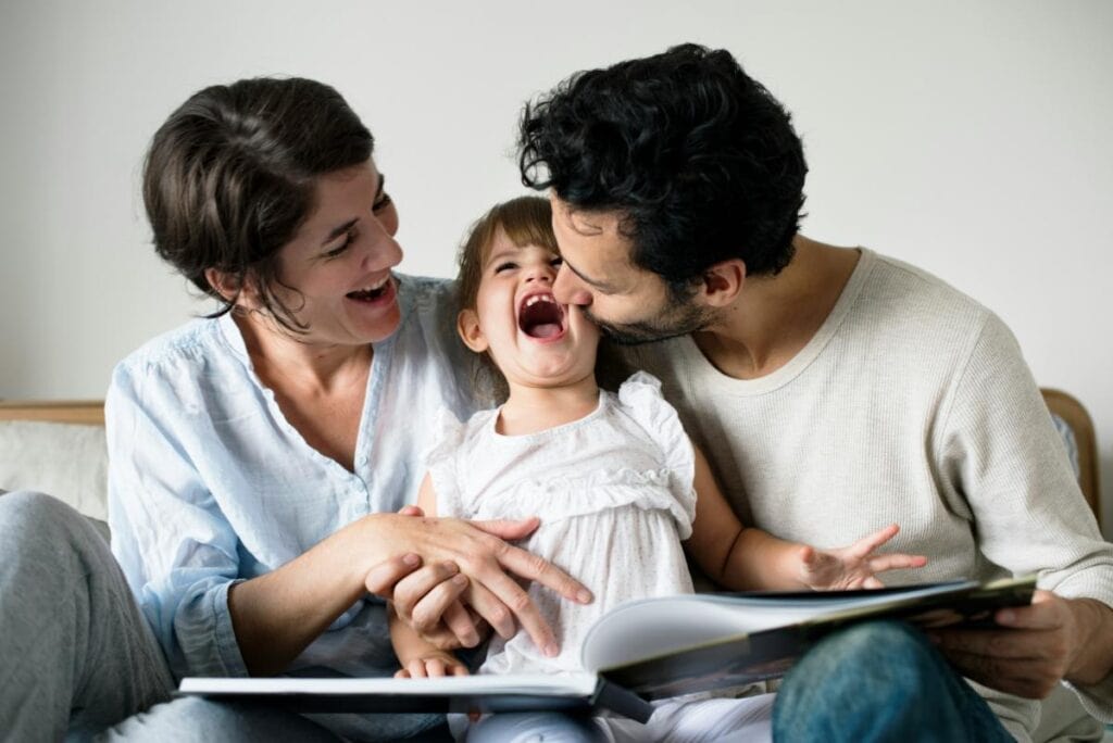 Happy family relaxing together, reading and laughing, showcasing the value of time saved by hiring professional cleaning services for a healthier home life.