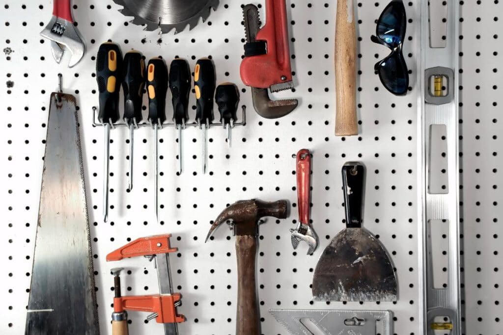 Organized pegboard wall displaying hand tools like screwdrivers, hammer, saw, and wrench, illustrating smart storage shed organization solutions.