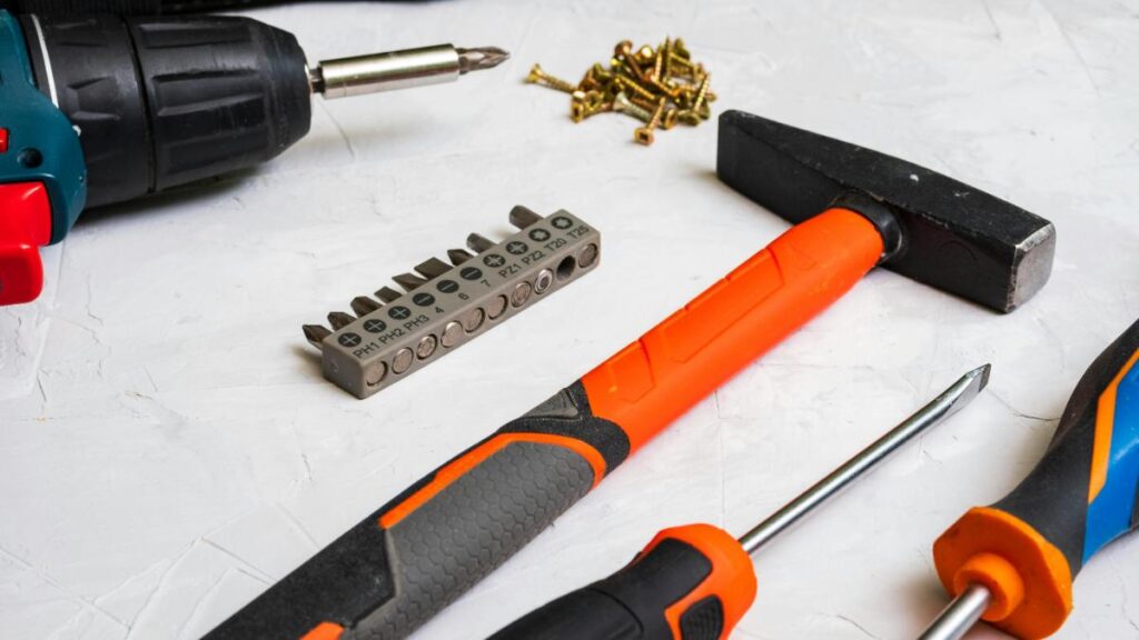 Essential DIY tools including a hammer, screwdriver, power drill, and drill bits—everything needed for easy weekend home improvement projects.