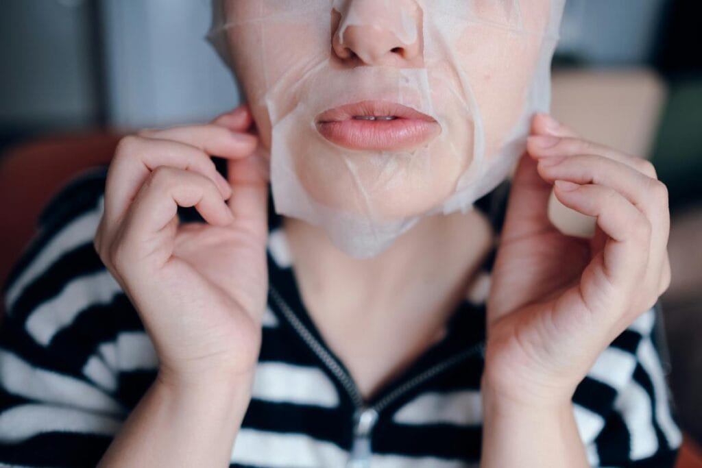 woman peeling off a face mask