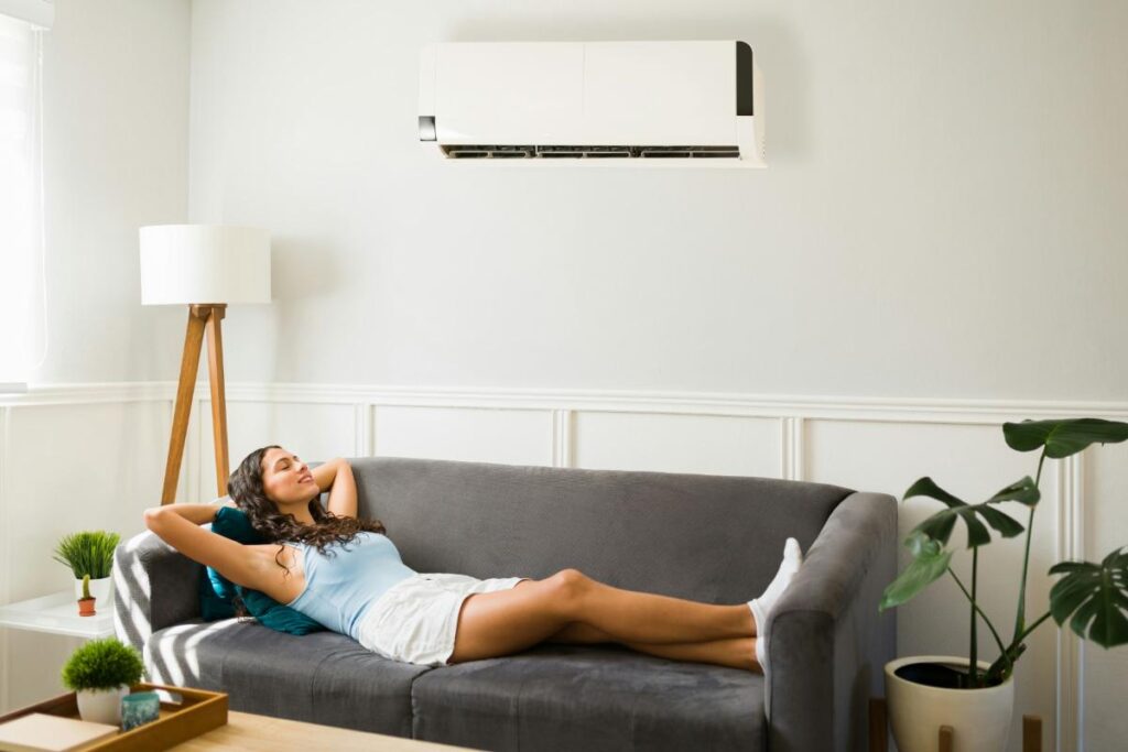 woman relaxing on couch under AC unit