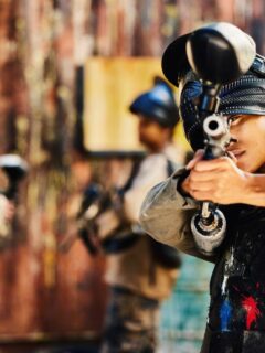 woman with paintball gun pointed at camera