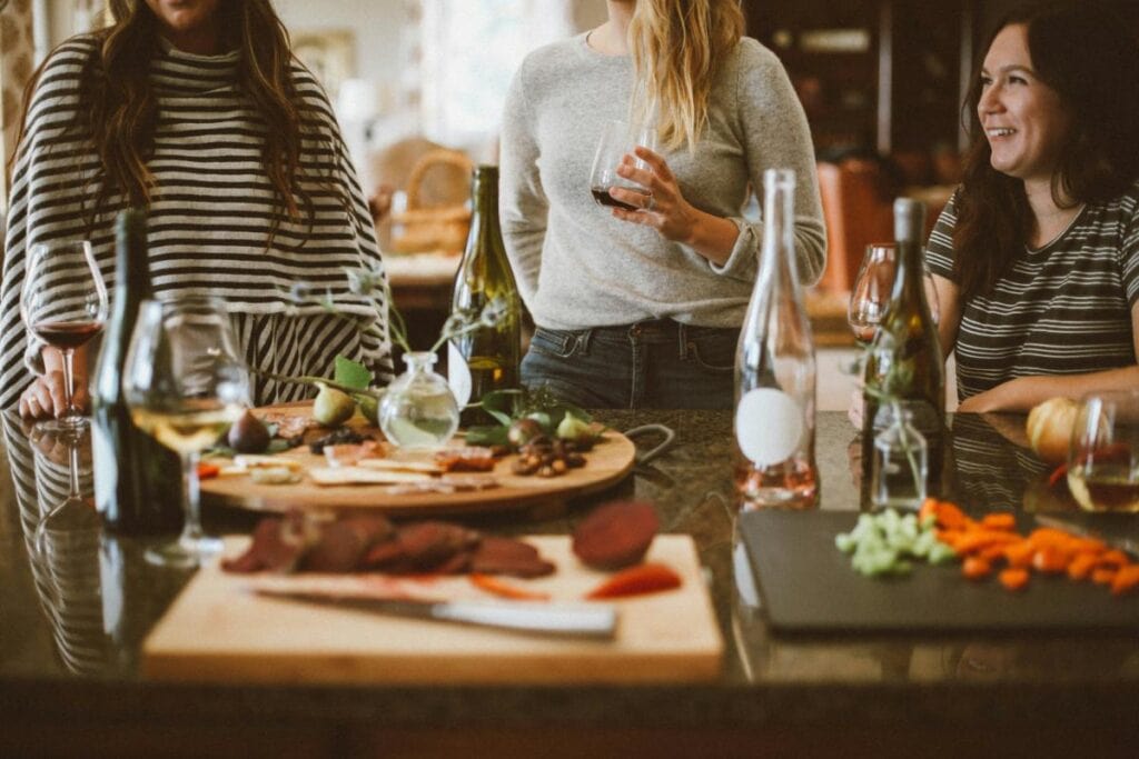a group of women drinking wine and sharing a charcuterie board