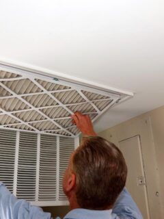 man replacing a dirty air filter in the hvac system