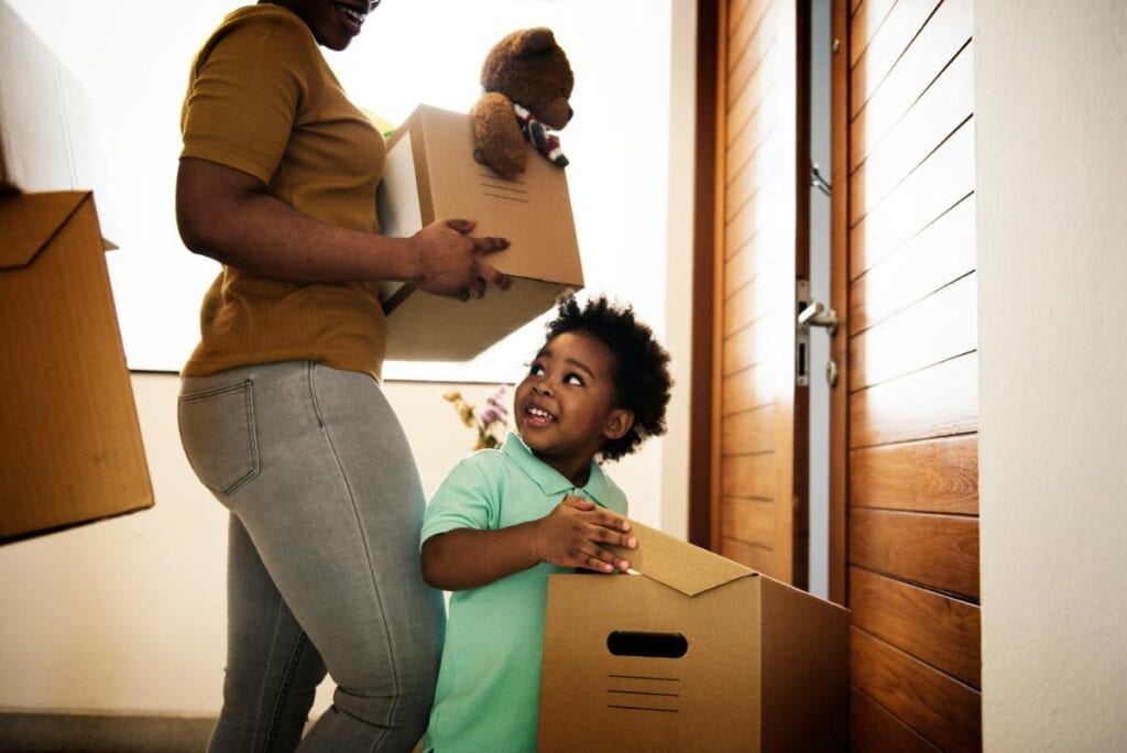family moving into their new home and carrying moving boxes