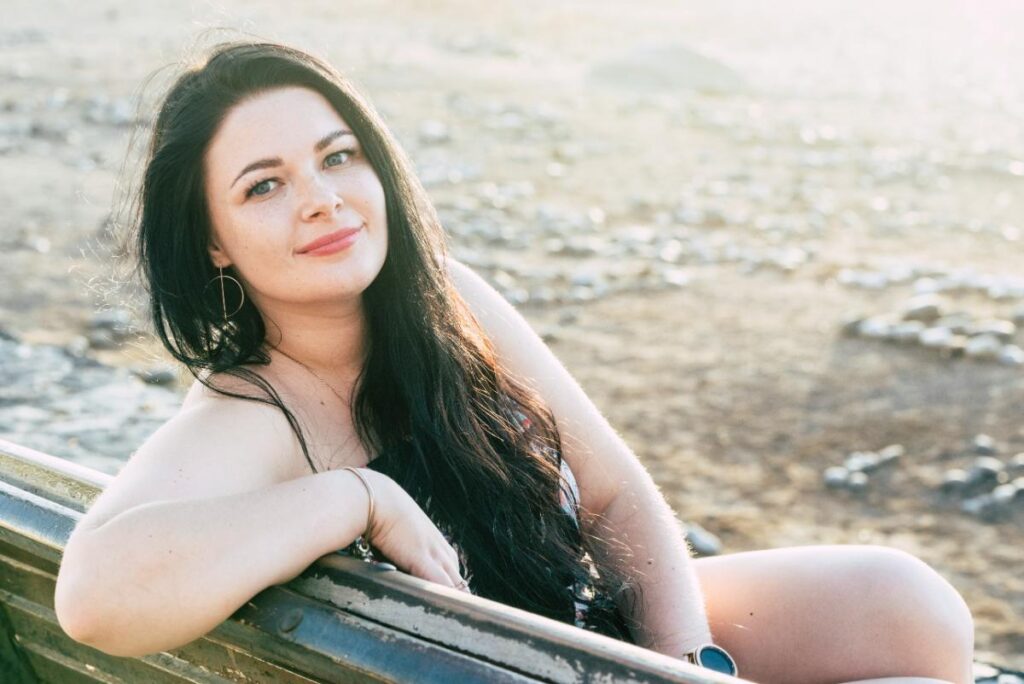 confident woman sitting on bench and smiling