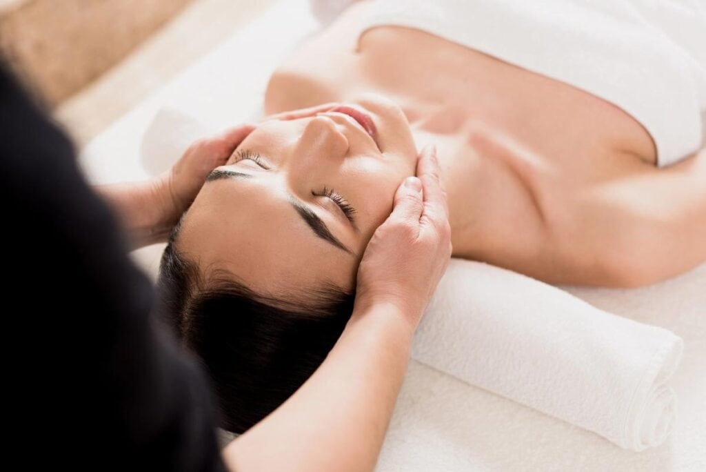 Woman receiving a relaxing facial massage at a med spa, showcasing self-care and rejuvenation for parents in a calming environment.