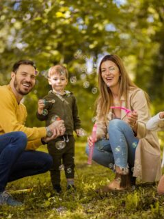 family outside in autumn blowing bubbles