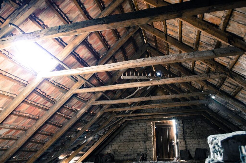 an old, dimly lit attic with focus on the rafters