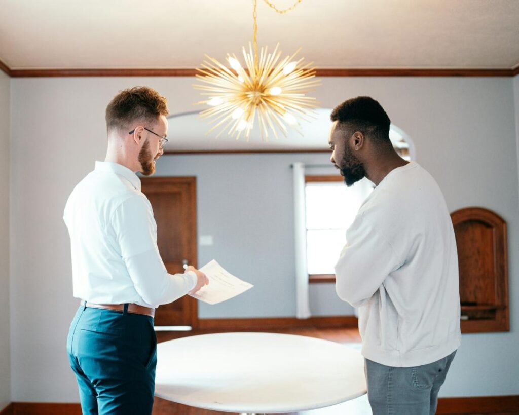 Landlord reviewing lease documents with a tenant in a bright dining room, highlighting clear communication and professional property management.
