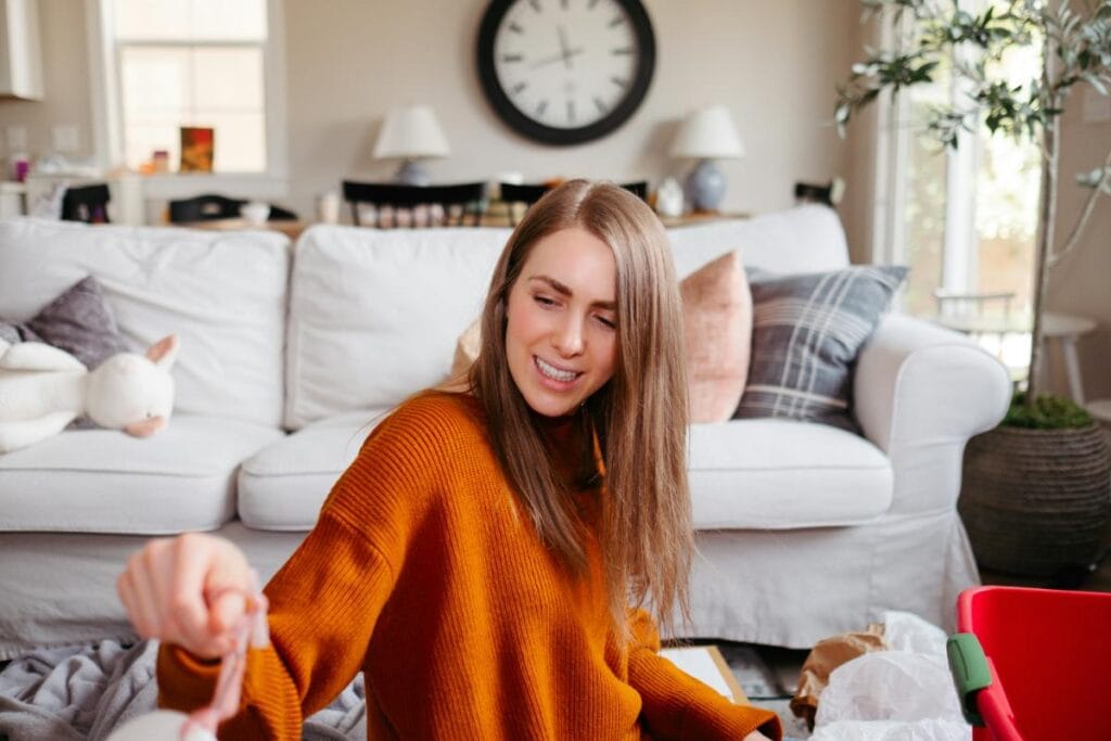 busy woman in living room in orange sweater