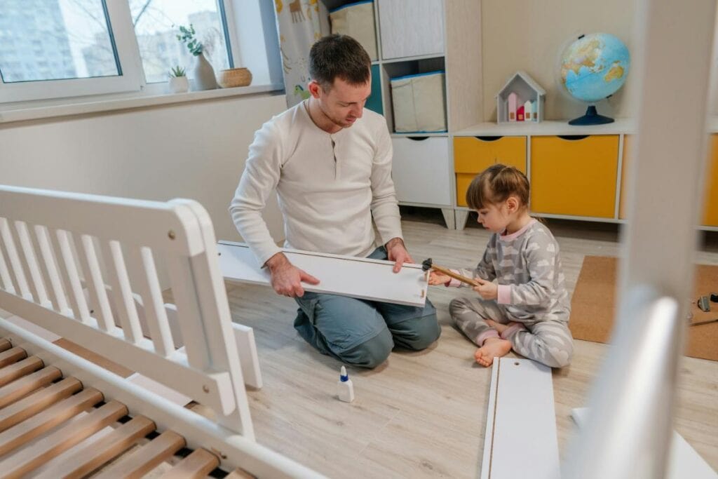 father and daughter assembling a bed