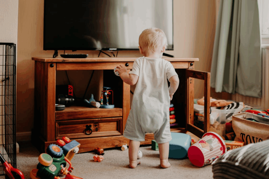 a toddler in the living room playing with toys that are scattered everywhere