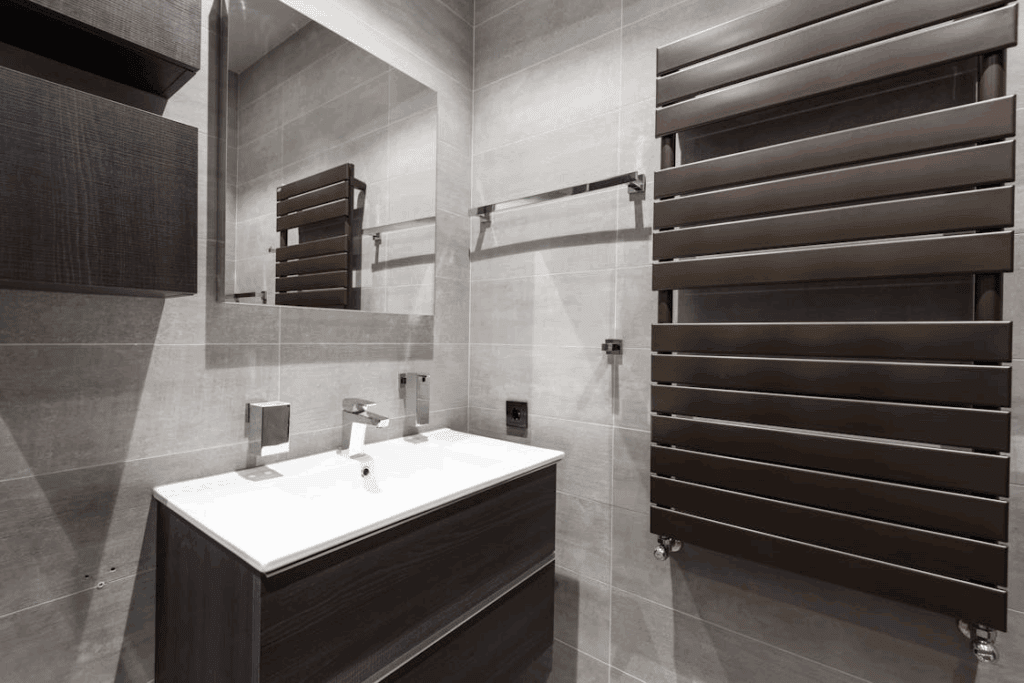 Contemporary bathroom renovation featuring a sleek vanity, wall mirror, and modern heated towel rail.