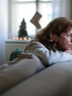an older woman looking sad and pensive during the holiday season