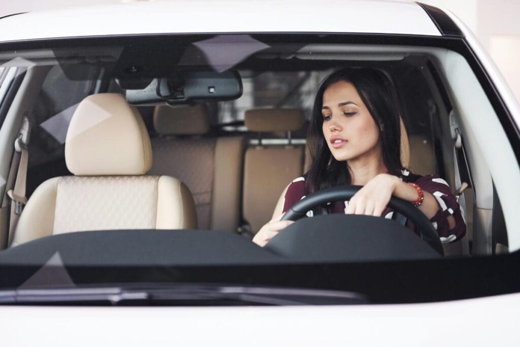 brunette woman in a car that needs to be transported