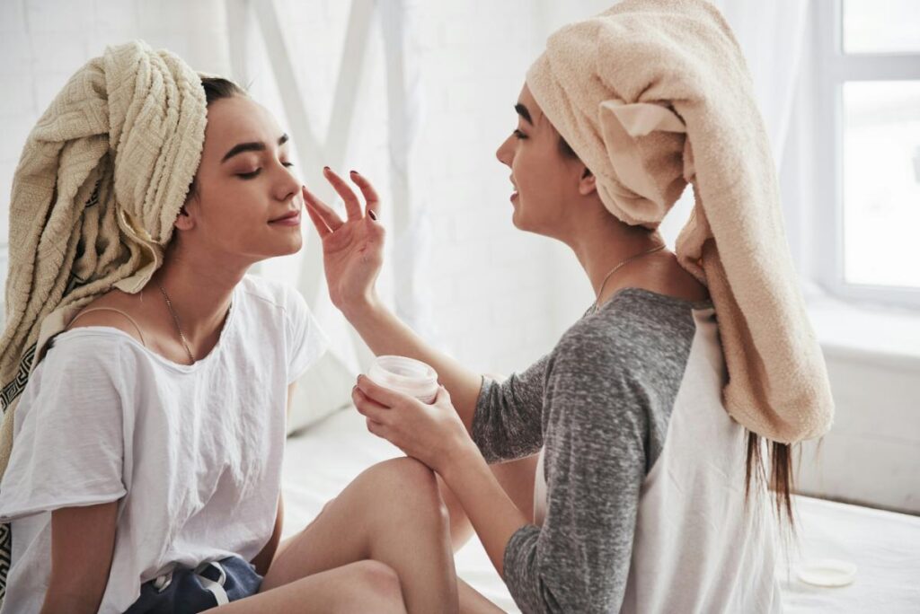 young women applying facial moisturizer