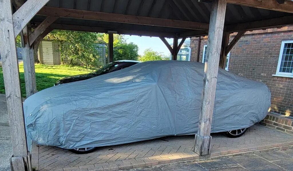 Waterproof car cover protecting the vehicle in carport