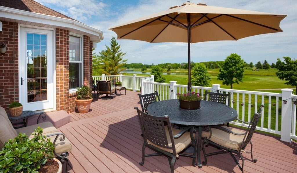 Sunny backyard deck with umbrella and lake view