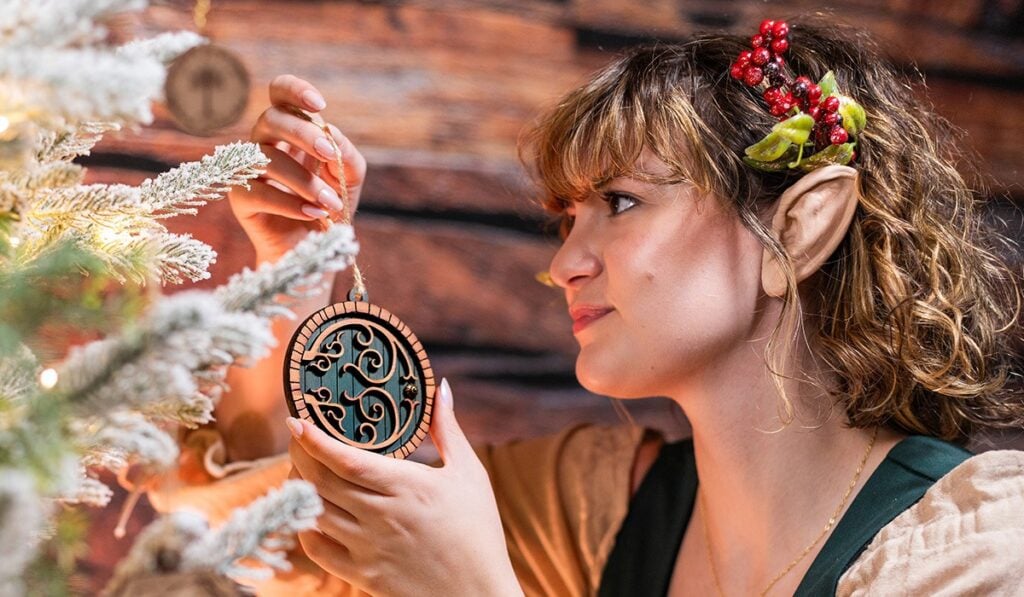 Woman wearing an elf costume decorating a Christmas tree