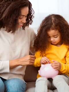 good financial self-care habits start at an early age - mom teaching daughter about saving money