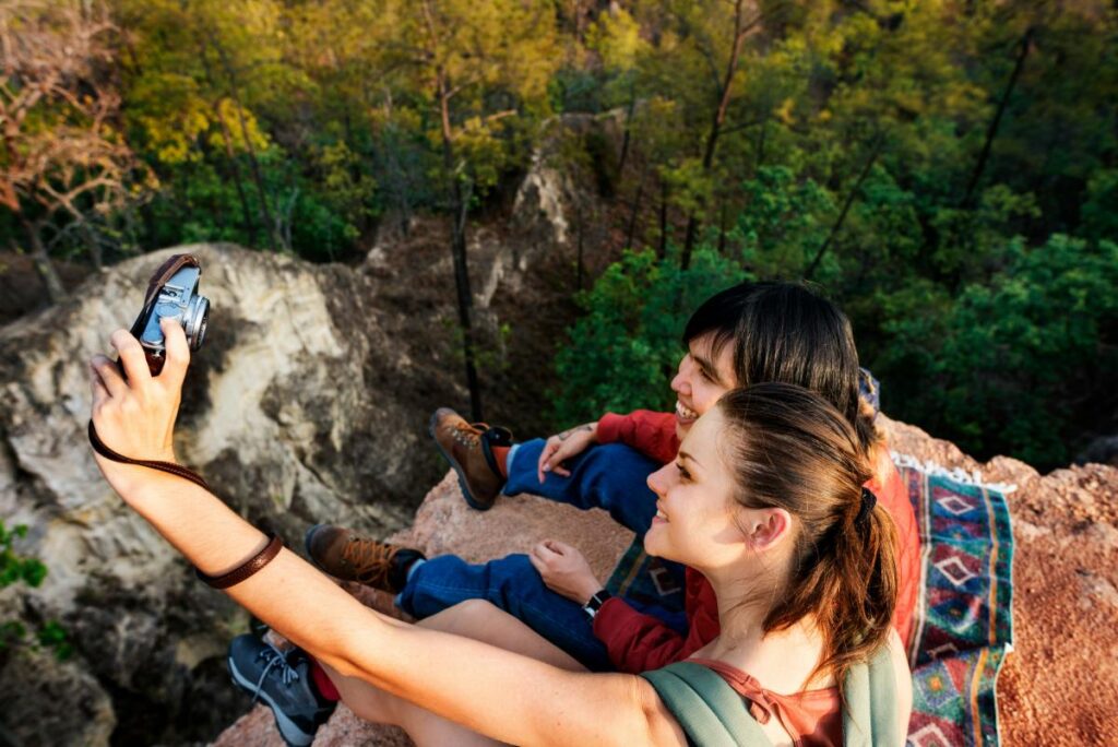 two friends taking photos while on a hike - perfect photos for a photo book printing project