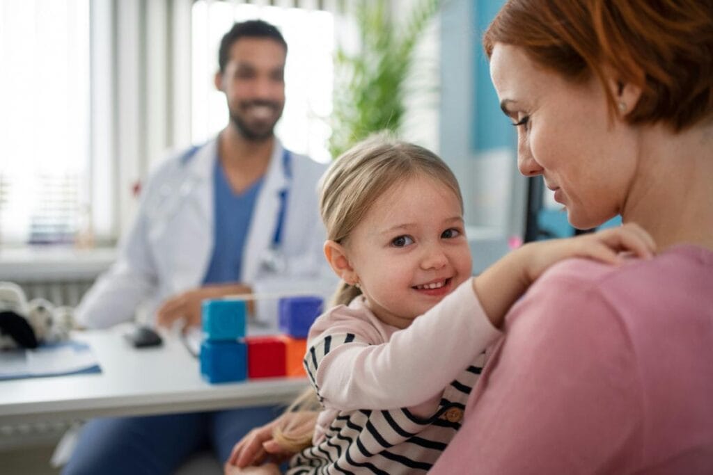 mom and daughter talking with pediatrician in office