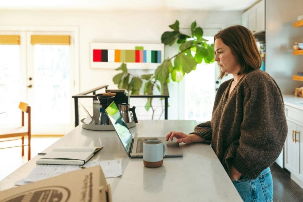woman using laptop at the kitchen counter