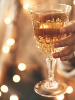 glass of champagne and soft christmas lights at a holiday party