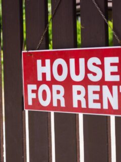 brown fence with a house for rent sign