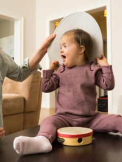 a toddler girl with down syndrome playing games with her mother