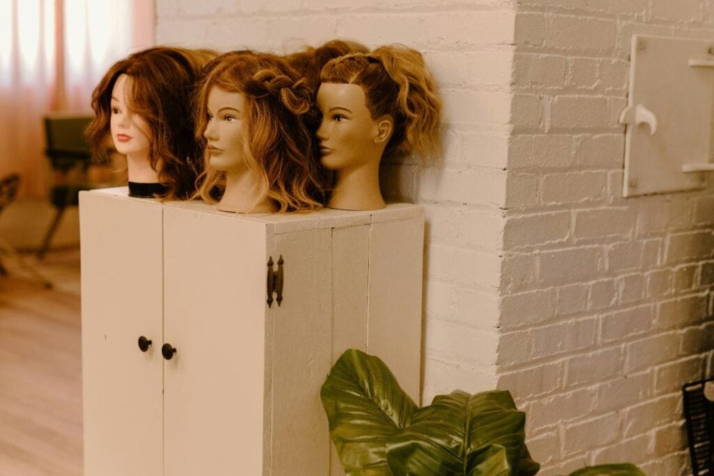 wigs displayed on mannequin heads, showing different hairstyles and colors for quick, polished hair options.