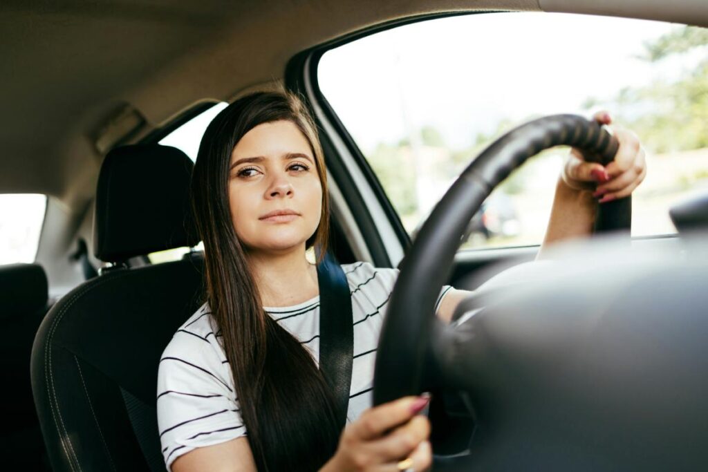 a brunette woman concentrating on safe driving