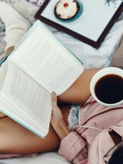 woman cozy in bed with book and tea