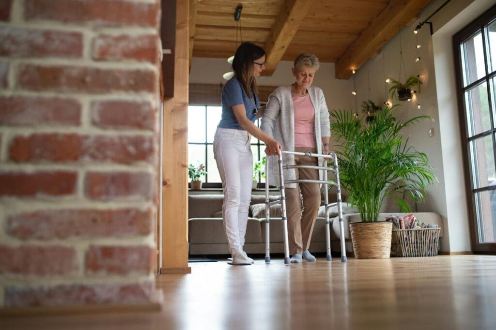 someone assisting an elderly woman using a walker