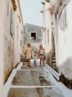 family on vacation walking through an alleyway