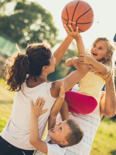 mom playing basketball with her kids, showing them a healthy and active lifestyle