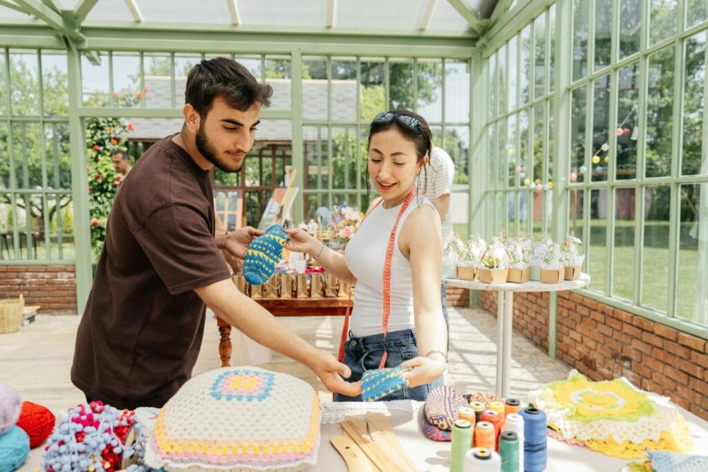 woman showing her crocheted goods to a male shopper