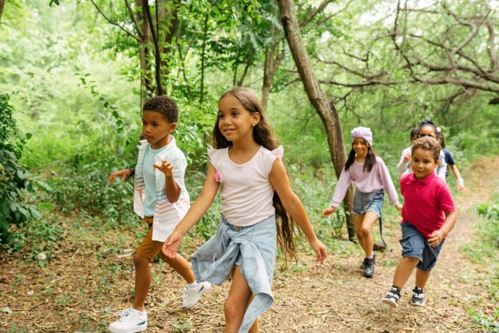 kids walking through the woods on a summer camp adventure