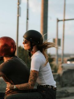 couple with helmets riding a motorcycle