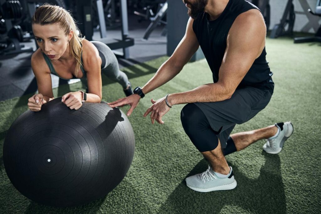 client using stability ball while trainer gives pointers