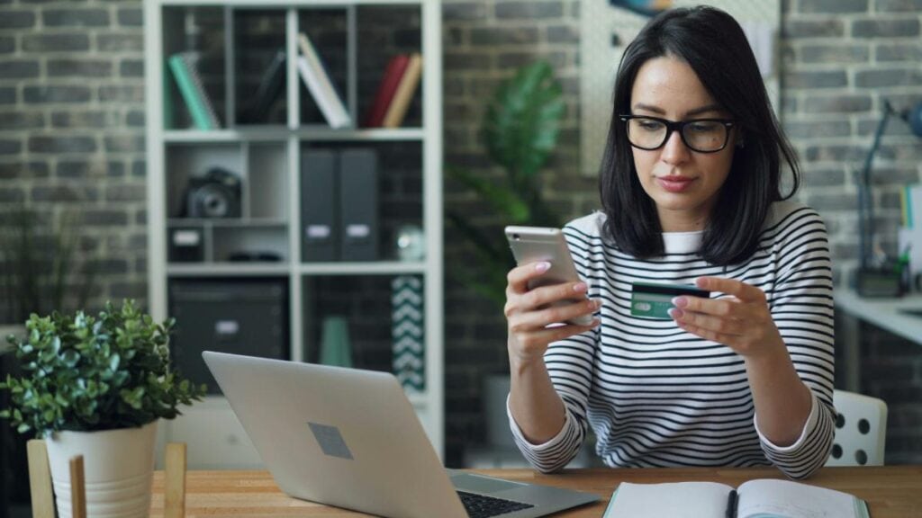 woman using credit cards to shop online