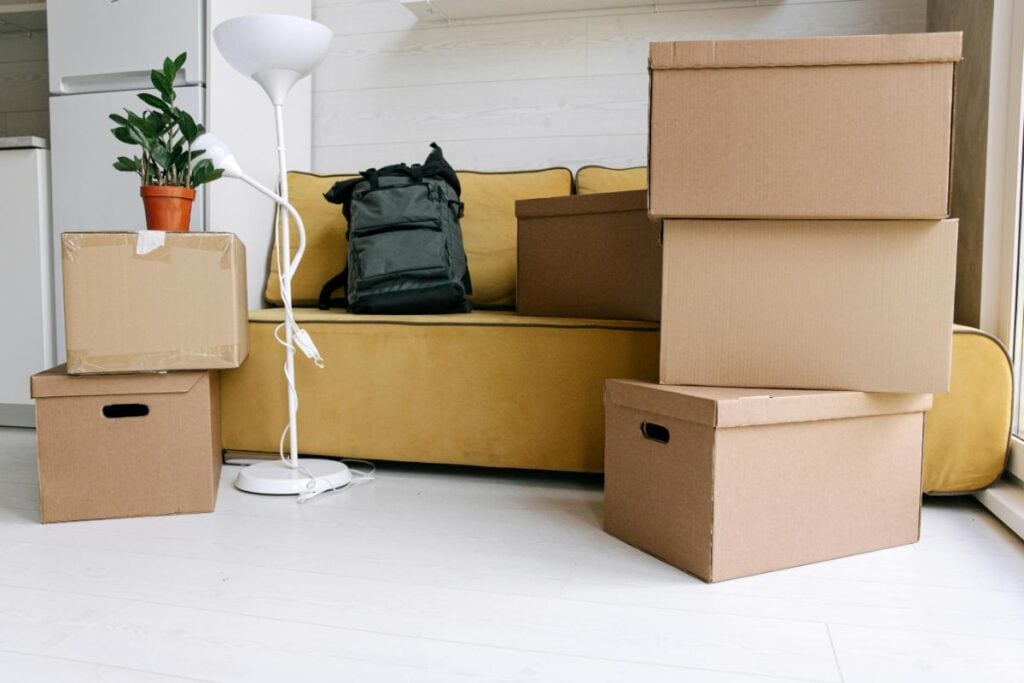 boxes stacked in front of a yellow couch